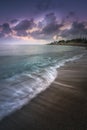 Scenic vertical shot of a seashore during twilight with the waves having a misty water effect