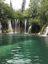 Scenic vertical view of a beautiful waterfall surrounded with evergreen trees Royalty Free Stock Photo