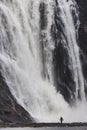 Scenic vertical view of a man fishing in the river next to the Montmorency Falls in Quebec, Canada Royalty Free Stock Photo