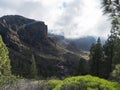 Scenic view of amazing landscape from path to Roque Nublo rock formation with winding road, mountains, green pine trees Royalty Free Stock Photo