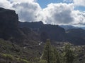 Scenic view of amazing landscape from path to Roque Nublo rock formation with winding road, mountains, green pine trees Royalty Free Stock Photo