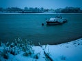 Scenic view of an anchored boat on a rippling water of Sava river during a gloomy and windy winter evening