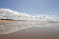 A scenic view on the beach with clouds reflected on the wet sand. Royalty Free Stock Photo