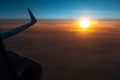 Scenic view of beautiful dark sunrise, cloudy sky and airplane wing with engine, through window of the aircraft during the flight. Royalty Free Stock Photo