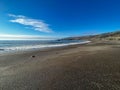 Scenic view of the beautiful ocean against a blue sky captured from a sandy shore Royalty Free Stock Photo