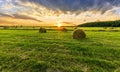 Scenic view at beautiful spring sunset in a green shiny field with green grass and golden sun rays, deep blue cloudy sky on a Royalty Free Stock Photo