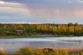 Scenic view at beautiful spring sunset on a shiny lake with green branches  birch trees  bushes  grass  calm water  deep blue Royalty Free Stock Photo