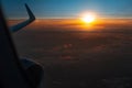 Scenic view of beautiful sunrise, cloudy sky and airplane wing with engine, through window of the aircraft during the flight. Copy Royalty Free Stock Photo