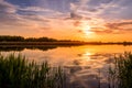 Scenic view of beautiful sunset or sunrise above the pond or lake at spring or early summer evening Royalty Free Stock Photo