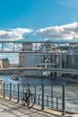 Scenic view of a bicycle leaning in a metal fence, with a boat riding in the Spree river and the metal architecture of