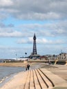 Scenic view of blackpool from the south with waves breaking on the steps, people on the promenade and the golden mile and tower in Royalty Free Stock Photo