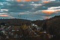 Scenic view of buildings among bare foliage trees under a cloudy sky in Ardennen, Belgium at sunset