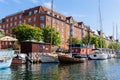 Scenic view Christianshavn Copenhagen canal marina embankment with many boats vessel yachts moored against green trees