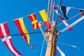 Scenic view of colorful flags hanging on ropes of a mast in blue sky background Royalty Free Stock Photo