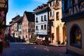 Scenic view of colorful half-timbered residences decorated with old shop signs in Riquewihr