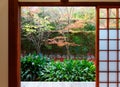Scenic view of colorful maple trees in the courtyard behind the sliding screen doors shoji of a traditional Japanese room Royalty Free Stock Photo