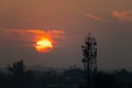 Communication tower silhouetted against sunset sky in Chittaurgarh, India Royalty Free Stock Photo