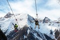 Scenic view couple of tourist with skiing equipment enjoy having fun riding extreme suspended zipline wire flying over gorge Royalty Free Stock Photo