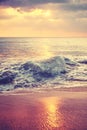 Scenic view of crashing surf at a beautiful sandy beach at sunset, color toning applied