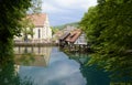 emerald-green lake Blautopf and historic old hammer mill, church, and timber-framed houses in the background (Germany)