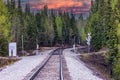 Scenic view of empty railroad tracks amid fir forest in Denali park at red sunset, Alaska Royalty Free Stock Photo