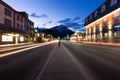 Scenic view of an empty road surrounded by illuminated buildings during nighttime in Banff, Alberta