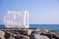 Scenic view empty white beach wooden canopies cabanas with white curtain blowing by wind against sea or ocean san Royalty Free Stock Photo