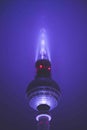 Scenic View Famous Alexanderplatz TV Tower of Berlin, Germany in Modern Futuristic Purple Light Color surrounded by Fog