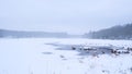 Scenic view a frozen lake with a water hole in the shore of the forest Royalty Free Stock Photo