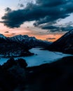 Scenic view of a frozen river surrounded by snow-capped mountains during sunset Royalty Free Stock Photo