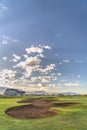 Scenic view at a golf course with focus on sand trap and fairway on a sunny day Royalty Free Stock Photo