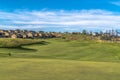 Scenic view of golf course and homes against blue sky and clouds on a sunny day Royalty Free Stock Photo