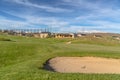 Scenic view of golf course and homes against blue sky and clouds on a sunny day Royalty Free Stock Photo