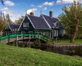 Scenic view of a green bridge spanning the river and leading to a quaint green cottage