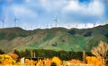 Scenic view of hay bales , wind turbines and mountains against sky Royalty Free Stock Photo