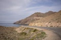 Scenic view of a highway road passing by the beautiful mountains and sea in Cabo de Gata, Spain Royalty Free Stock Photo