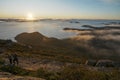 Scenic view of hikers on the coastline against the sea at sunset Royalty Free Stock Photo