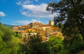 Scenic view on hill with picturesque medieval mediterranean village with church, blue sky, fluffy clouds - Ramatuelle, France Royalty Free Stock Photo