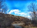 Scenic view of a hillside under a bright blue sky in early spring Royalty Free Stock Photo