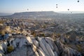 Scenic view of hot air balloons flying over stone formations in Cappadocia, Turkey. Royalty Free Stock Photo