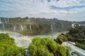 Scenic view of the Iguazzu waterfalls in Brazil. The sun creates rainbows in the spray when there are gaps in the clouds.