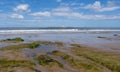 Scenic view of an island in a sea against a rocky beach under a  cloudy blue sky Royalty Free Stock Photo