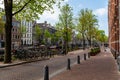 Scenic view of Kloveniersburgwal canal with typical Dutch houses in Amsterdam in early morning Royalty Free Stock Photo