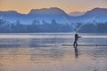 Scenic view of a lake in a quiet morning with silhouette of a fisherman