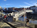 A scenic view of the landmark Hapenny Bridge spanning over the Liffey River in Dublin, Ireland.