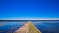 Scenic view of a long jetty in Tuggerah lake under a clear blue sky Royalty Free Stock Photo