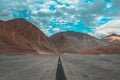 a long paved road winds through the desert mountains in a remote area