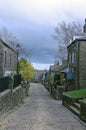 Scenic view of the main street in the village of heptonstall in west yorkshire with old stone houses and a cloudy sky