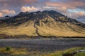 Scenic view of majestic mountain against cloudy sky during sunset