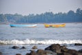 Scenic view of manori beach with two boats floating on water and boulders in foreground Royalty Free Stock Photo